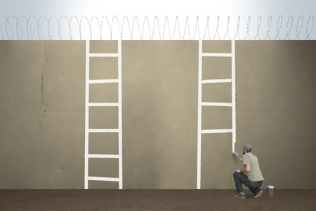 A man draws ladders on a border barrier.の写真素材