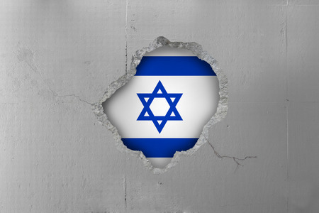 Israeli flag behind a concrete wall.の写真素材