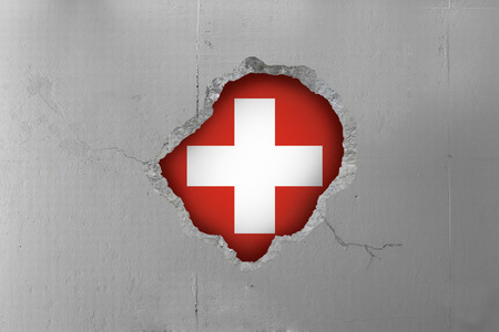 Switzerland's flag behind a concrete wall.の写真素材