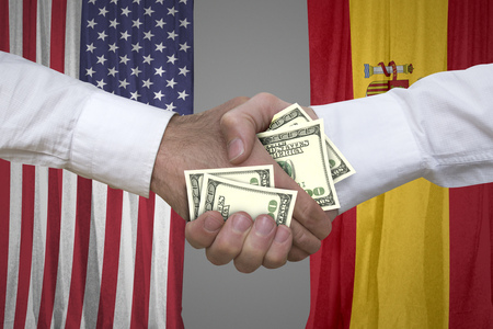 100 dollar bills handshake with USA and Spanish flags background.の写真素材