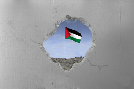Palestinian flag behind a concrete wall.の写真素材