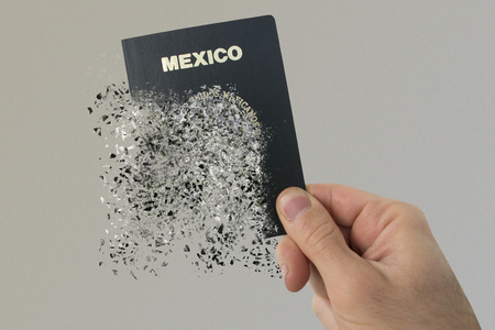 Mexican passport pulverizes in a man's hand.の写真素材
