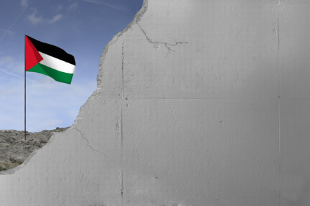 Palestinian flag behind a concrete wall.の写真素材