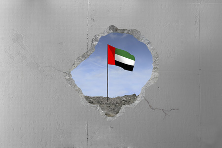 United Arab Emirates's flag behind a concrete wall.の写真素材