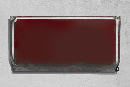 Rusty violet metallic sign with rough wall background.の写真素材