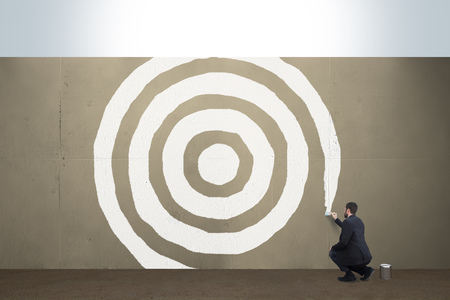 A business man draws a target on a concrete barrier.の写真素材