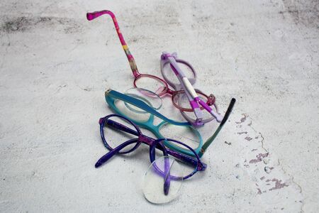 Broken children`s glasses. The glasses have ruined rims, missing the side temple. They have fallen glass and are scratched.の写真素材