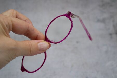 Woman holding old, broken children`s glasses without templeの写真素材