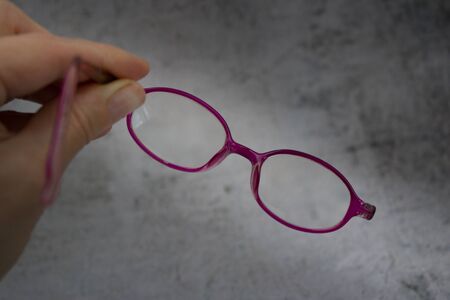 Woman holding old, broken children`s glasses without templeの写真素材