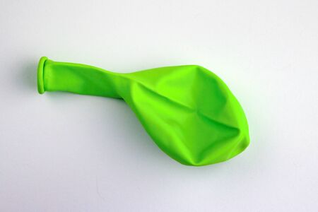 Uninflated green balloon isolated on white background.Green Inflatable balloon not inflated on white backdrop.の写真素材