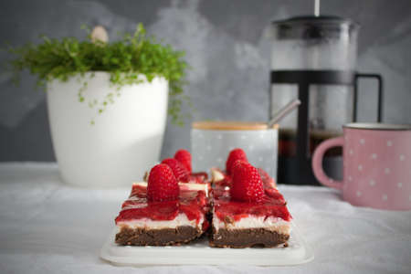Raspberry cheescake brownies pieces with fresh berries and coffee on the table. Good morning. Sweet...