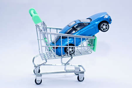 Blue passenger car in a shopping cart. Ideal time to buy a new car or car accessories.
