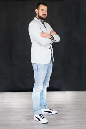 Young man standing on office and smiling. Working photo from the office. Careless elegance and casual style.の写真素材