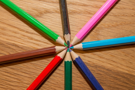 Color pencils in circle on wooden tableの写真素材