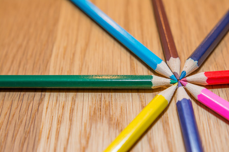 Color pencils in circle on wooden tableの写真素材