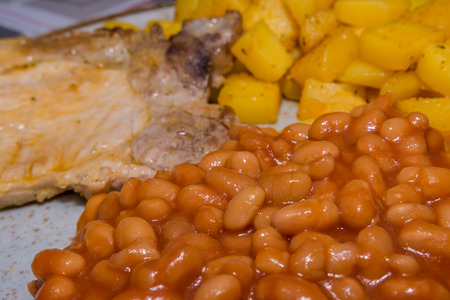 White beans in tomato sauce with spiced potatoes and meatの写真素材