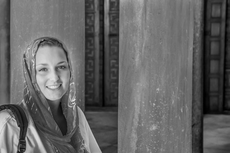 Beautiful young woman wearing kerchief in a mosque in Tunisia, in black and whiteの写真素材
