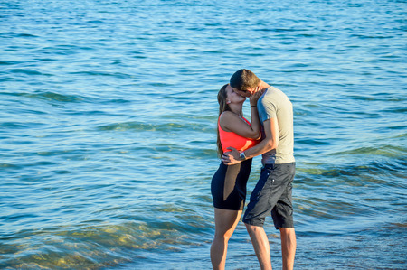 Young couple giving passionate kiss at beachの写真素材