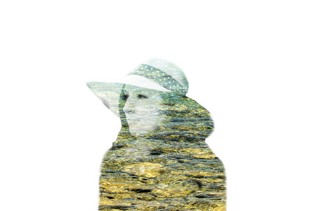 Woman wearing hat and red dress, sitting in natureの写真素材