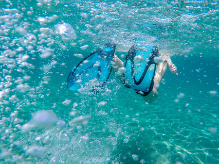 Flippers moving through water with air bubbles