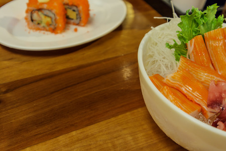Japanese food 'sashimi' in a bowl have octopus and salmol with sushi rolls