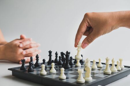 hand holding chess pieces on board with white background, driven to success Business Strategy.