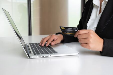 Business woman consumer spending via credit card for online shopping on her laptop.の写真素材