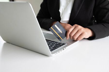 Business woman consumer spending via credit card for online shopping on her laptop.