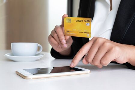 Business woman consumer holding credit card and smartphone for online shopping and payment make a...