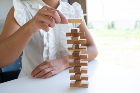 hand playing blocks wood game, gambling placing wooden block. Concept Risk of management and strategy plan, growth business success process.の写真素材