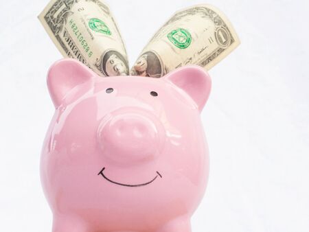 Pink piggy bank with dollars bank note, Saving money for future plan and retirement fund concept.の写真素材