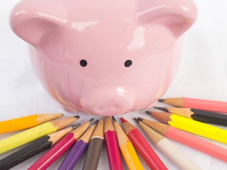 Pink piggy bank with Bright colored pencils, Saving money for future plan and retirement fund concept.の写真素材