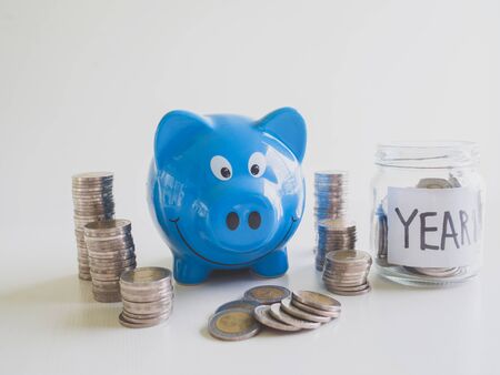 Blue Piggy bank with coins pile saving money in year one, Saving money for future plan and retirement fund concept.の写真素材