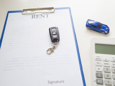 A car rent service lease contract with key and calculatorの写真素材