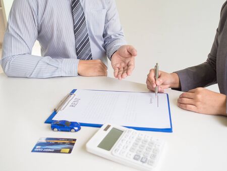 Business woman used credit card and signed for rent car form salesman.の写真素材
