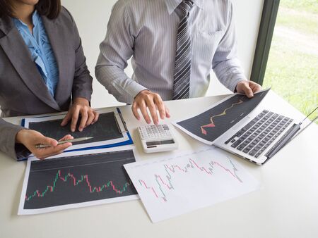 Businessman and businesswoman discussion and 
analyze stock graph report, set targets for online trading management success.の写真素材