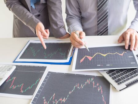Businessman and businesswoman discussion and 
analyze stock graph report, set targets for online trading management success.の写真素材