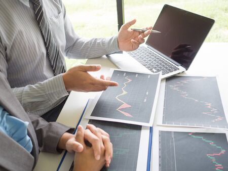 Trader team discussion and analyze stock graph report, set targets for online trading management success.の写真素材