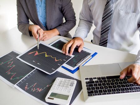 Trader team discussion and analyze stock graph report, set targets for online trading management success.の写真素材