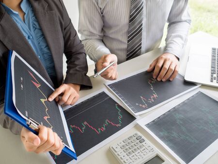 Trader team discussion and analyze stock graph report, set targets for online trading management success.の写真素材