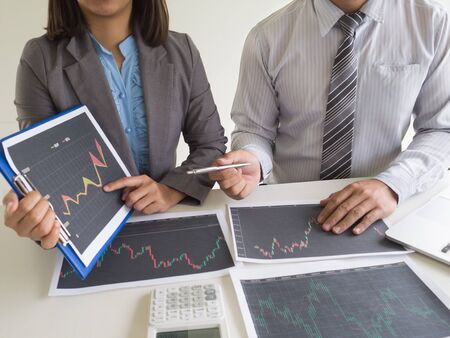 Trader team discussion and analyze stock graph report, set targets for online trading management success.の写真素材