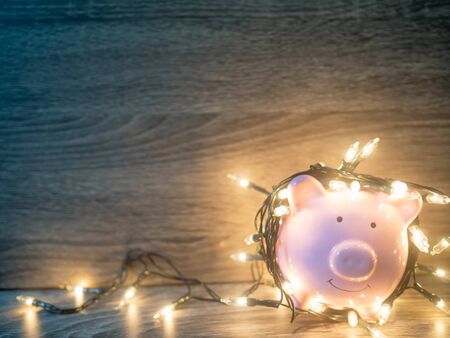 Pink piggy bank with Party lights, Enjoy savings for the holidays concept.