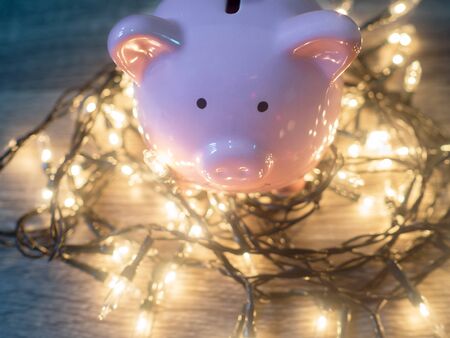 Pink piggy bank with Party lights, Enjoy savings for the holidays concept.の写真素材