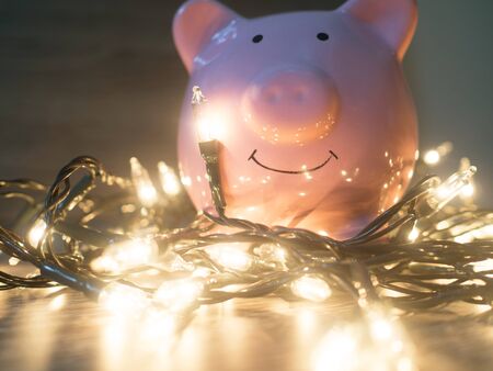 Pink piggy bank with Party lights, Enjoy savings for the holidays concept.の写真素材