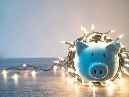 Blue piggy bank with Party lights, Enjoy savings for the holidays concept.の写真素材