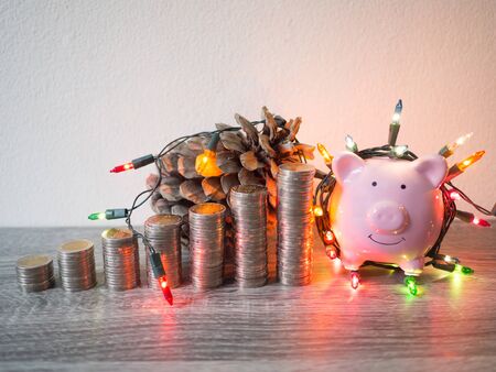 Pink piggy bank with coins pile growth graph and Party lights, Funly saving money for future investment plan and retirement fund concept.の写真素材