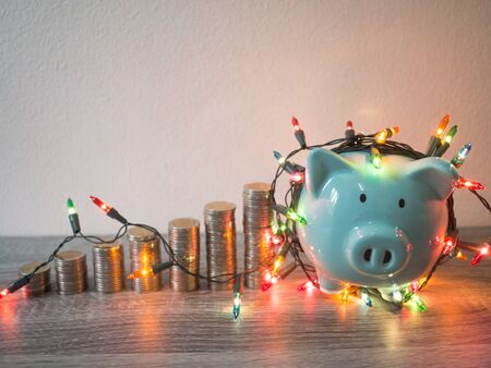 Blue piggy bank with coins pile growth graph and Party lights, Funly saving money for future investment plan and retirement fund concept.の写真素材