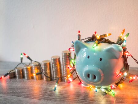 Blue piggy bank with coins pile growth graph and Party lights, Funly saving money for future investment plan and retirement fund concept.の写真素材
