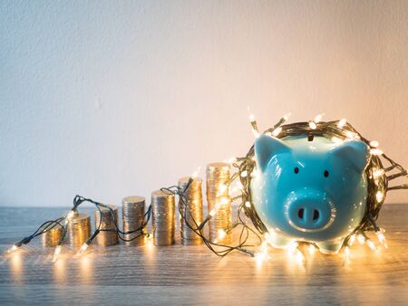 Blue piggy bank with coins pile growth graph and Party lights, Funly saving money for future investment plan and retirement fund concept.の写真素材