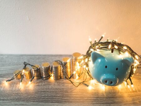 Blue piggy bank with coins pile growth graph and Party lights, Funly saving money for future investment plan and retirement fund concept.の写真素材